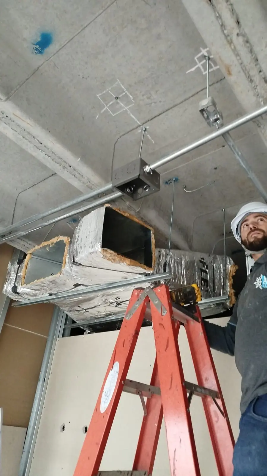 Técnico da A&L instalando dutos de climatização numa obra