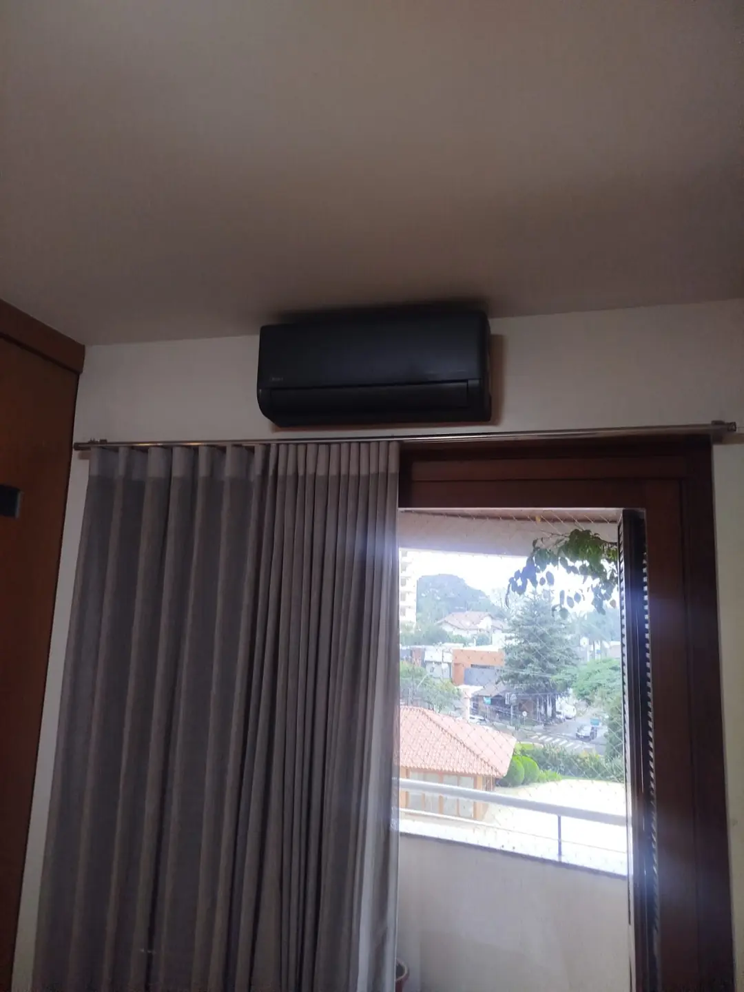 Split instalado em quarto com cortina