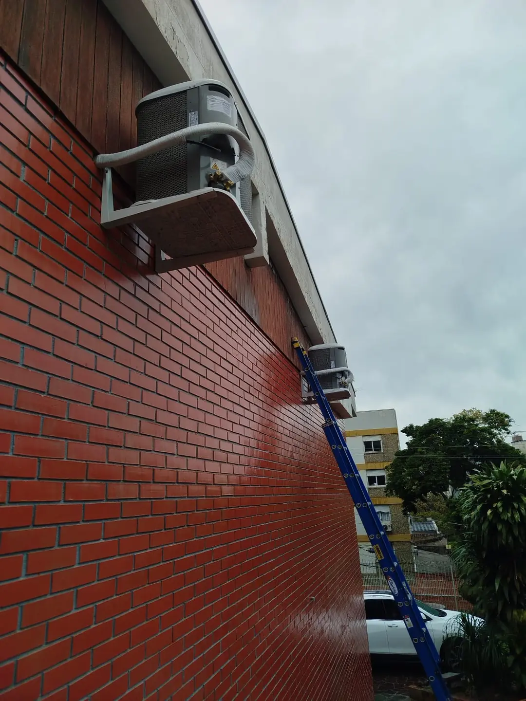 Condensadoras em suportes numa fachada de tijolo